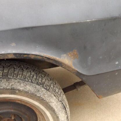 Drivers side outer quarter panel wheel lip area has small rust spot